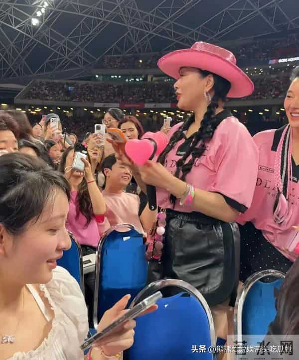 55岁钟丽缇现身新加坡看韩国女团演唱会，穿着粉色上衣，活力满满