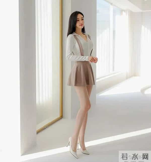 白色V领长袖上衣搭配浅棕色高腰背带A字裙。