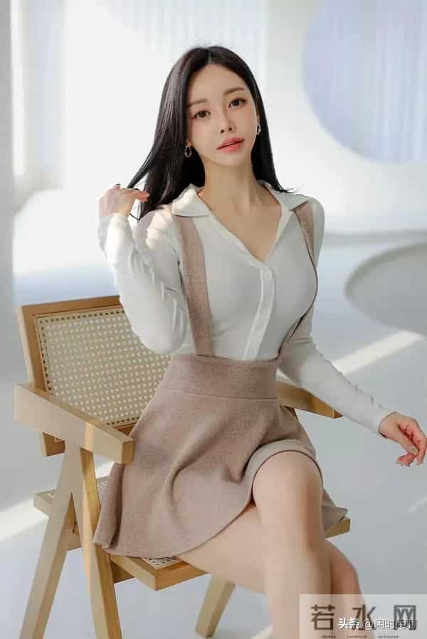 白色V领长袖上衣搭配浅棕色高腰背带A字裙。