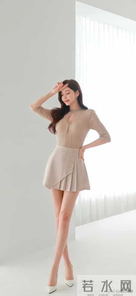 浅杏镂空针织配百褶短裙，不对称剪裁金扣点睛。